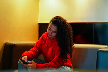 Latin social influencer girl using smartphone with yellow background - Happy Latin girl having fun with new trends technology - Fashion, tech and millennial generation activity - Focus on face - Image