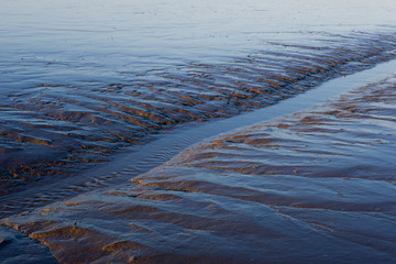 Ein Priel verläuft diagonal im Wattenmeer