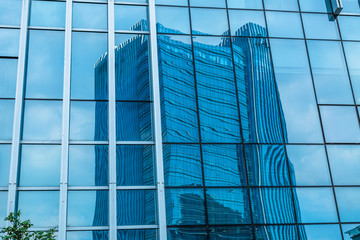 Fototapeta na wymiar Glass wall of business center and sky reflection.