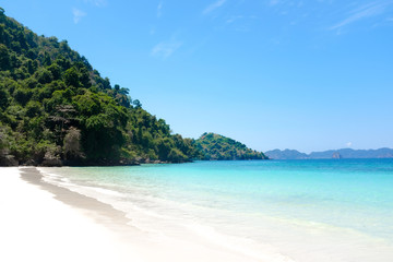 Tropical sand beach island and crystal clear sea water in sunny day. Vacation and holiday in paradise island.