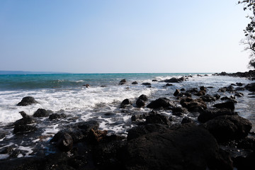 Sea wave breaks on beach rocks landscape. Sea waves crash and splash on rocks. Beach rock sea wave breaking