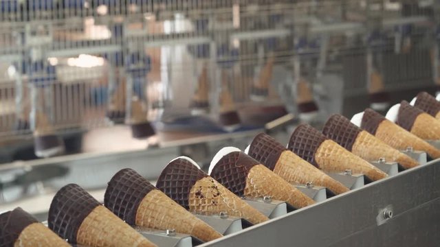 ice cream production, transportation waffle-cone with plombir ice cream on conveyor, production line, dairy products.