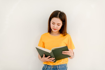 Asian girl holding a green book in front of her