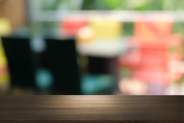 Empty dark wooden table in front of abstract blurred bokeh background of restaurant . can be used for display or montage your products.Mock up for space.