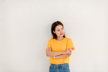 Beautiful Asian woman confident in a yellow sweater and jeans on a white background.