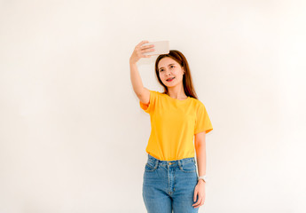 Asian women holding phones while selfies Asian women with smiling faces, smiling selfies on a white background Women taking selfies