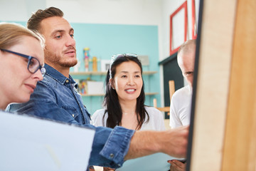 Maler und Besucher zusammen vor einer Staffelei