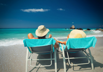 Couple on sunbeds relaxing at the beach in Lefkada