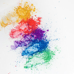 Bright eye shadows in different colors of the rainbow, scattered on a white background.