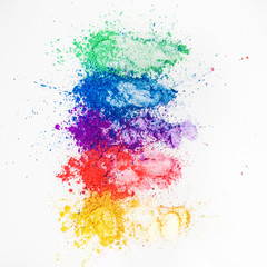 Bright eye shadows in different colors of the rainbow, scattered on a white background.