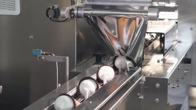 ice cream production, transportation waffle-cone with plombir ice cream on production line, packaging process, dairy products.
