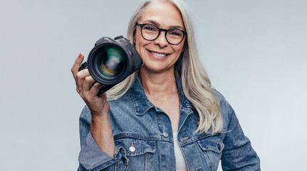 Professional female photographer with dslr camera - obrazy, fototapety, plakaty