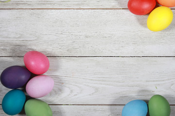 Colorful Easter eggs on white wooden table. Easter background concept. Blank copy space, mockup, frame, border