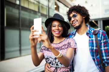 Young couple taking a selfie and having fun outdoors.