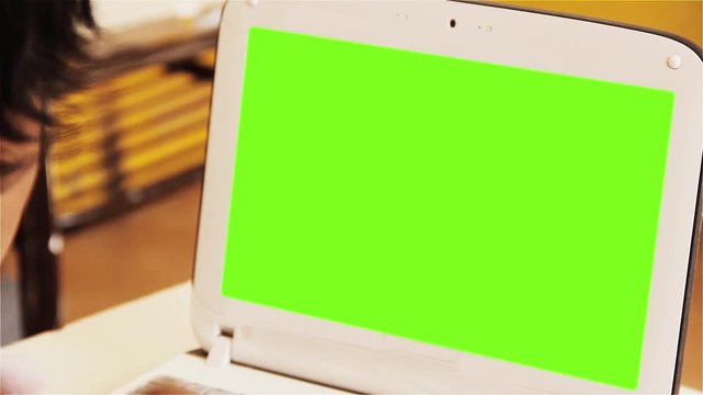 Male Student using a White Netbook with Green Screen inside Classroom at School. Close Up.