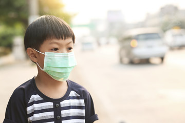A 5 years old boy wearing a medicine healthcare mask on the street.