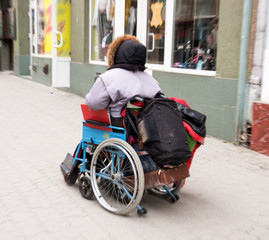 Old woman in wheelchair on thestreet of the city . Intentional motion blur