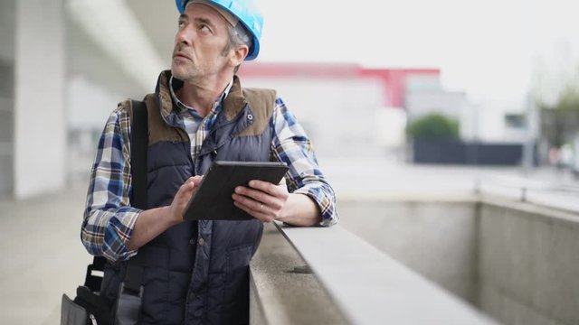 Lead architect construction worker checking work sight with tablet