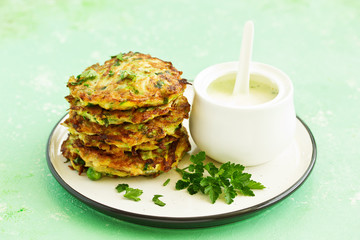 Zucchini fritters and peas with sour cream sauce