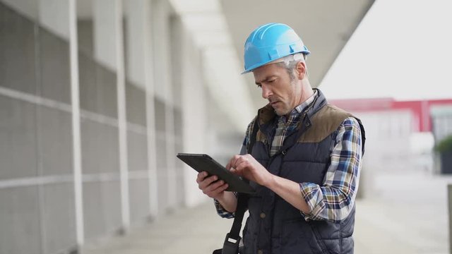 Lead architect construction worker checking work sight with tablet