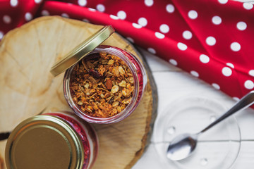 Summer fruit red berry breakfast. Healthy cherry split breakfast with cream cheese, granola, nuts and dried fruits white chocolate. In mason jar, on table. Copy space