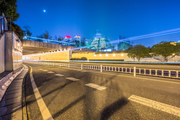 Fototapeta premium urban traffic road with cityscape in background at night, China.