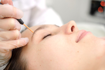 Medical treatment removal of birthmark from female patient's face. Female dermatologist surgeon...