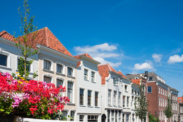 Fototapeta premium row white houses in street Turfmarkt in Gouda, The Netherlands. Against blue sky