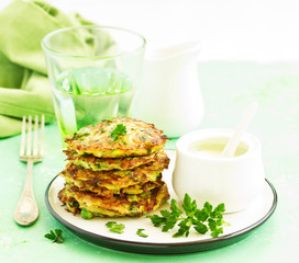 Zucchini fritters and peas with sour cream sauce