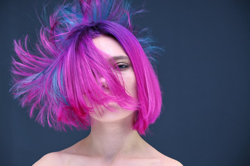 Concept Portrait of a punk girl, young woman with chic purple hair color in studio close up on a colorful background with fluttering hair. - 260697064