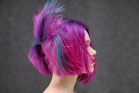 Concept Portrait Of A Punk Girl, Young Woman With Chic Purple Hair Color In Studio Close Up On A Colorful Background With Fluttering Hair.