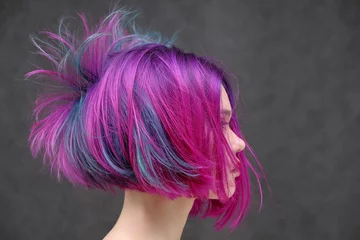Foto auf Acrylglas Antireflex Konzept Portrait eines Punk-Mädchens, junge Frau mit schicker lila Haarfarbe im Studio hautnah auf einem bunten Hintergrund mit flatternden Haaren. © Вячеслав Чичаев