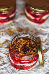 Summer fruit red berry breakfast. Healthy cherry split breakfast with cream cheese, granola, nuts and dried fruits white chocolate. In mason jar, on table. Copy space