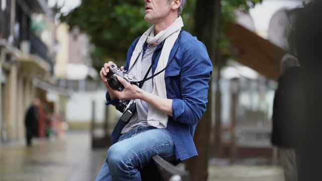 Photographer taking photos with vintage camera in European town