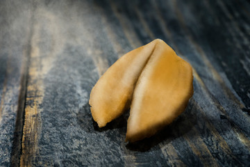 Fortune Cookie on wooden table with a piece of hope paper inside.