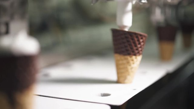 ice cream production, waffle cup ice cream filling process, transportation waffle-cone with plombir ice cream on production line, dairy products.