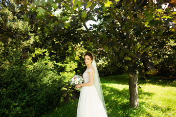 Obraz na płótnie Canvas Bride in fashion wedding dress on natural background. A beautiful woman portrait in the park