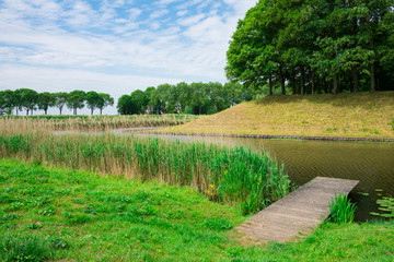 water landscape with canal, dike and trees in fortified village Klundert, The Netherlands