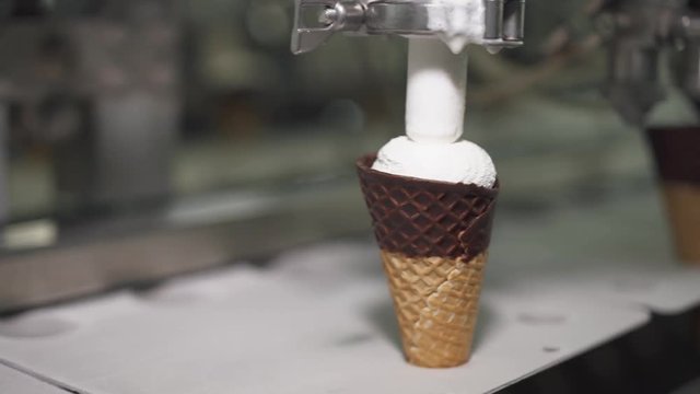 ice cream production, waffle cup ice cream filling process, transportation waffle-cone with plombir ice cream on production line, dairy products.