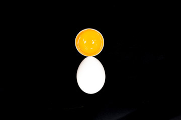 Chicken white egg with raw broken yellow yolk. Top view.  