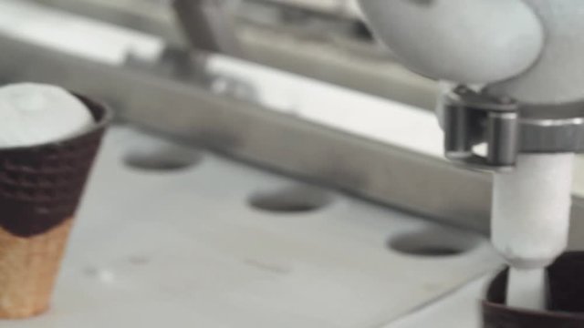 ice cream production, waffle cup ice cream filling process, transportation waffle-cone with plombir ice cream on production line, dairy products.
