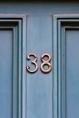 Elegantly framed house number 38 with the thirty eight centered on the wooden house door