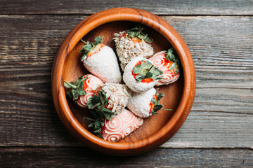 Strawberries covered with chocolate in the wooden bowl. Selective focus. Shallow depth of field. 