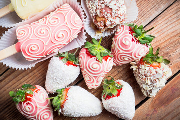 Strawberries and bananas covered with chocolate on the rustic background. Selective focus. Shallow depth of field.