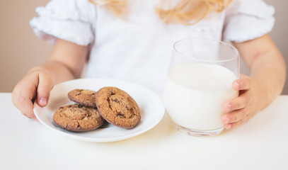 Little blond girl drink a glass of milk with different emotions, indoor, healthy food concept