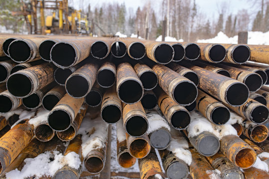 Offshore Industry oil and gas production petroleum pipeline. Downhole drilling rig. Laying the pipe on the deck. View of the shell of drill pipes laid in courtyard of the oil and gas warehouse.