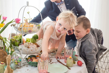 Obraz na płótnie Canvas Polish children misbehaving, making a mess at Easter family table.