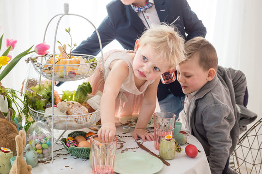 Polish children misbehaving, making a mess at Easter family table.