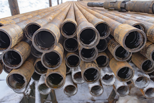 Offshore Industry oil and gas production petroleum pipeline. Downhole drilling rig. Laying the pipe on the deck. View of the shell of drill pipes laid in courtyard of the oil and gas warehouse.