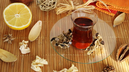 Tea cup with tea leaves. cozy autumn or winter morning at home. Still life details with cup of tea, sketch book with herbarium